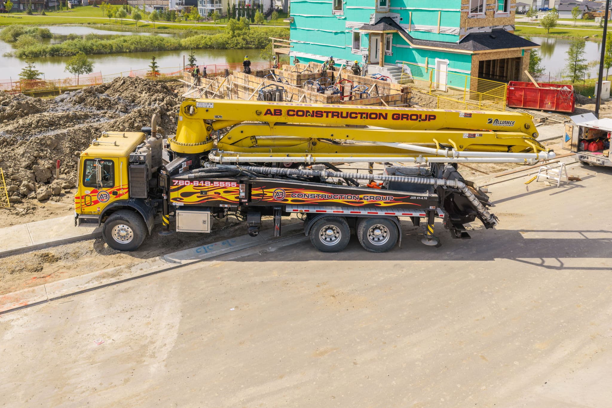 AB Construction Group Alliance boom pump truck set up on a residential job site in Spruce Grove, Alberta