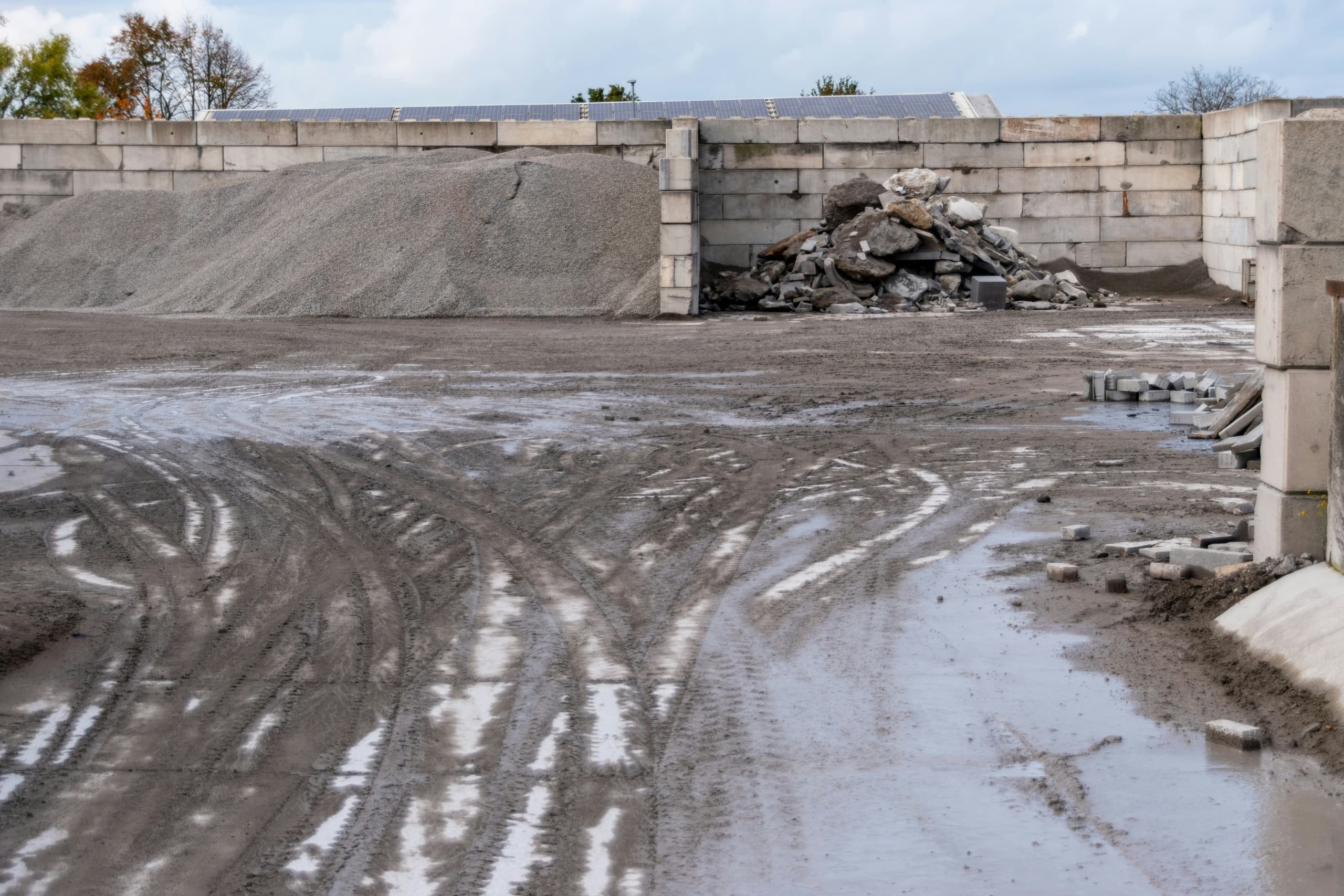 Excavator loading material beside a dump truck